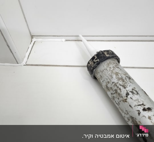 אקדח סיליקון לבן על פינה אטומה
